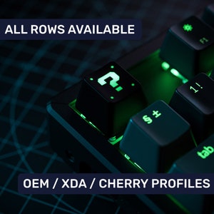 Puede incluir: Un teclado mecánico negro con retroiluminación verde. El teclado tiene una tecla de signo de interrogación, una tecla de tabulación y una tecla con el símbolo "§±". El texto "ALL ROWS AVAILABLE" y "OEM / XDA / CHERRY PROFILES" es visible en la imagen.