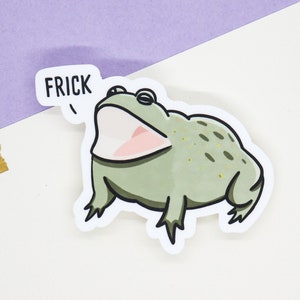 May include: A green frog sticker with a wide open mouth and the word "FRICK" in a speech bubble above it.