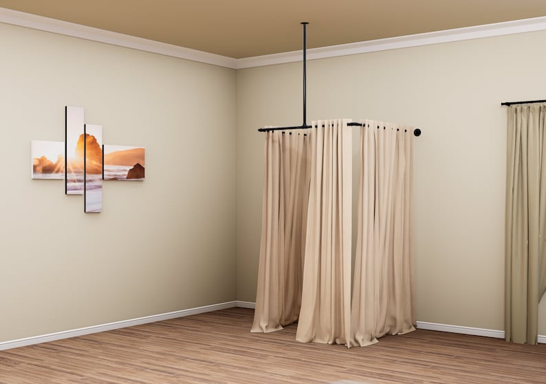 Puede incluir: Un sistema de barra de cortina de metal negro con cortinas beige colgadas. La barra est&aacute; unida al techo y se extiende para crear un recinto cuadrado. Las cortinas est&aacute;n completamente cerradas, creando un espacio privado.