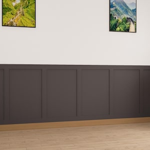 May include: A room with dark gray wainscoting and a wood floor. There are two framed landscape pictures on the wall above the wainscoting. A potted plant is in the corner of the room.