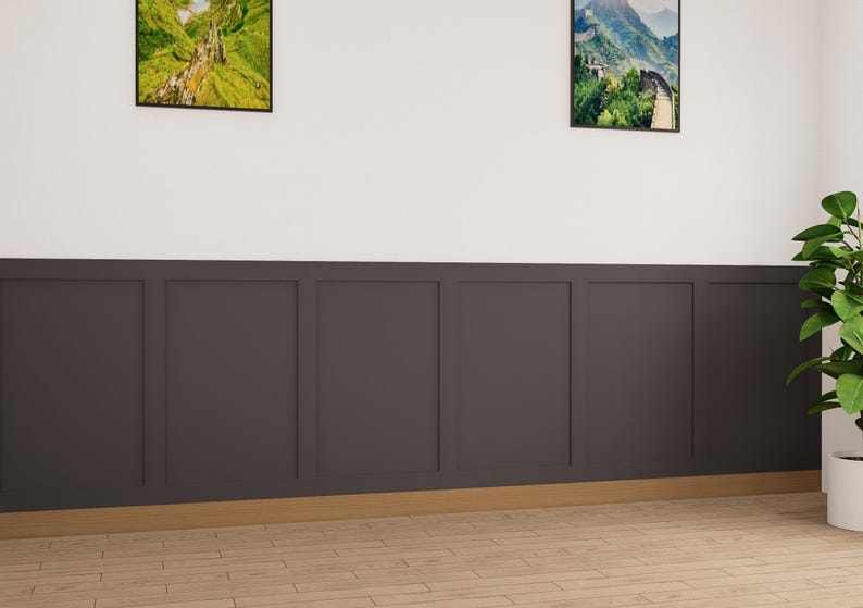 May include: A room with dark gray wainscoting and a wood floor. There are two framed landscape pictures on the wall above the wainscoting. A potted plant is in the corner of the room.