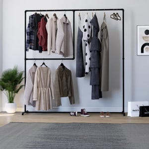 May include: A black metal clothes rail displaying a variety of garments. The clothes include shirts, jackets, and dresses in neutral tones, with a few pieces in burgundy and black and white polka dots. Accessories like shoes and shopping bags are visible.