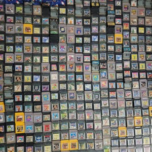 Può includere: Una vasta collezione di cartucce di giochi Game Boy vintage. Le cartucce sono in vari colori, tra cui grigio, giallo e nero, e presentano etichette di gioco colorate. L'immagine mostra una vasta gamma di titoli di videogiochi classici.