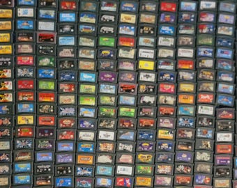 May include: A large collection of colourful Game Boy Advance game cartridges. The cartridges are arranged in rows and columns, and they feature a variety of different game titles.
