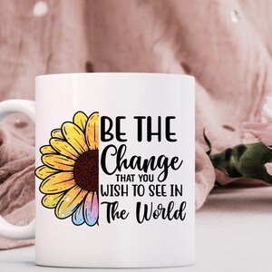K&ouml;nnte beinhalten: Wei&szlig;e Keramiktasse mit einer schwarz-wei&szlig;en Grafik einer Sonnenblume und dem Text "Sei die Ver&auml;nderung, die du in der Welt sehen m&ouml;chtest".