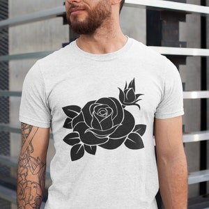 May include: A light gray t-shirt featuring a large black rose design. The graphic includes a fully bloomed rose, a bud, and several leaves. The shirt is made of a soft material.