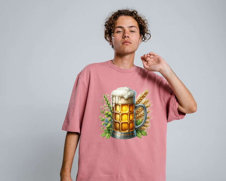 May include: A pink t-shirt with a graphic of a beer stein with a foamy head, surrounded by wheat stalks and green leaves.