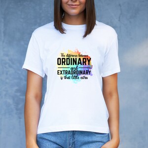 K&ouml;nnte beinhalten: Wei&szlig;es T-Shirt mit einem Regenbogen-Aquarellhintergrund und dem Text "The difference between ORDINARY and EXTRAORDINARY is that little extra."