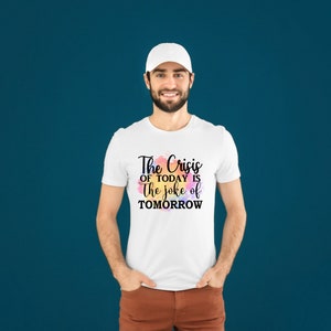 K&ouml;nnte beinhalten: Wei&szlig;es T-Shirt mit einem schwarzen Aufdruck, der "The Crisis of Today is the Joke of Tomorrow" lautet.
