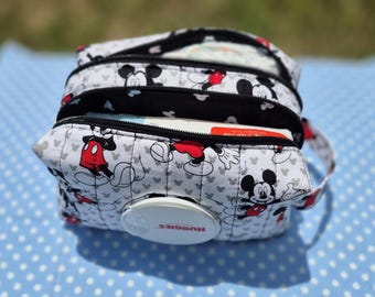 May include: A quilted fabric pouch featuring a repeating Mickey Mouse pattern in black, white, and red. The pouch has two zippered compartments and a circular white plastic Huggies brand dispenser opening on the front panel for easy access.