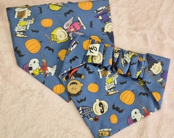 May include: Two blue Halloween-themed bandanas with a repeating pattern of cartoon characters dressed in costumes, orange pumpkins, and black bats. One bandana is folded, and the other is unfolded.