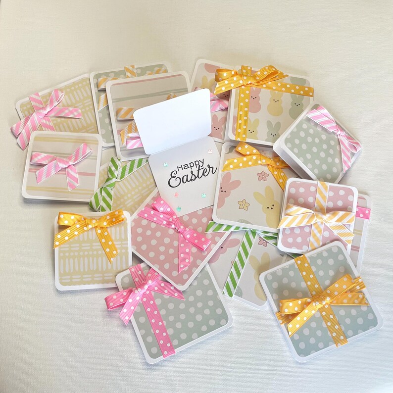 May include: A collection of square Easter gift tags with pastel patterns, polka dots, and bunny designs. Each tag is adorned with a colorful ribbon, with the words "Happy Easter" on one tag.