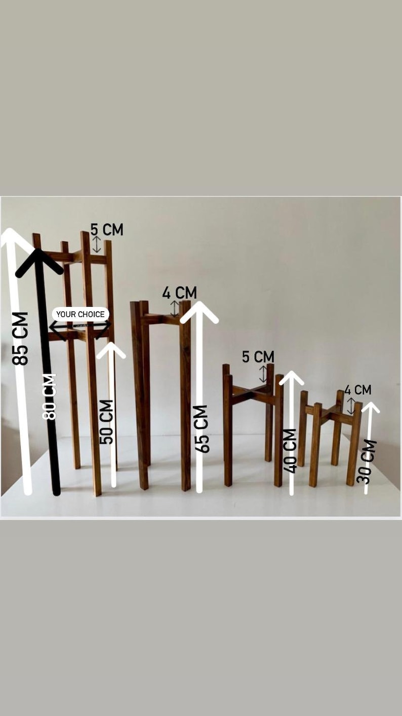 May include: Five wooden plant stands in different sizes. The stands are made of natural wood and have a simple, minimalist design. The stands are 30 cm, 40 cm, 50 cm, 65 cm, and 85 cm tall. The stands are 4 cm and 5 cm wide. The text "YOUR CHOICE" is written on the largest stand.