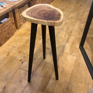 Puede incluir: Una mesa auxiliar de madera con una tapa de madera natural y patas de metal negro. La tapa de la mesa tiene forma de corazón y presenta un patrón de veta único.