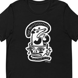 May include: Black t-shirt featuring a white graphic design. The design includes a possum emerging from a cup with the text "TOO MUCH EVERYTHING" and "ALL THE TIME". A skull and teardrop are also part of the design.