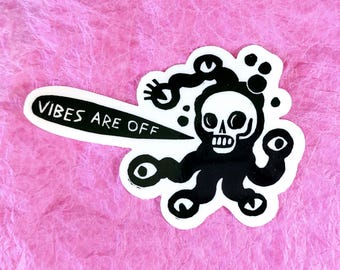 Puede incluir: Pegatina en blanco y negro con una criatura parecida a un cráneo con múltiples ojos y el texto "Vibes Are Off".