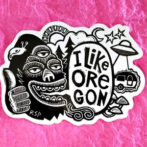 May include: Black and white sticker featuring a cartoon monster with the text "I like Oregon". The design includes a thumbs up, UFO, camper, and other illustrations related to Oregon, USA.