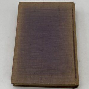 May include: A vintage book with a worn, textured cover. The cover is primarily a muted purple color, with a gradient effect. The edges and spine are a faded brown. The book appears to be well-used, with signs of age.