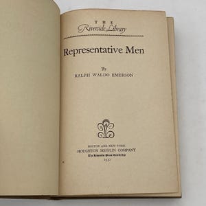 May include: Open book with the title "Representative Men" by Ralph Waldo Emerson. The book is part of "The Riverside Library" series, published by Houghton Mifflin Company in 1930. The pages are aged with a cream color.