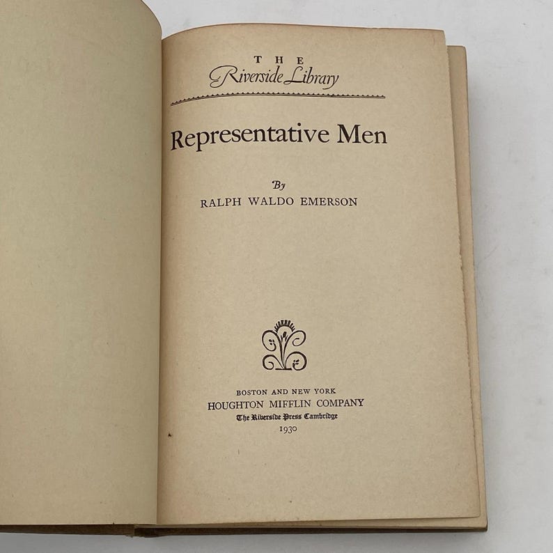 May include: Open book with the title "Representative Men" by Ralph Waldo Emerson. The book is part of "The Riverside Library" series, published by Houghton Mifflin Company in 1930. The pages are aged with a cream color.