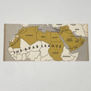 May include: A vintage map of the Arab League, featuring countries in shades of tan and gray. The map highlights the geographical boundaries of member states, with the text "THE ARAB LEAGUE" prominently displayed across the center.