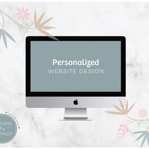 May include: A computer screen displaying the text "Personalized Website Design" with a light blue background. The computer is on a white marble surface with a floral design on either side.