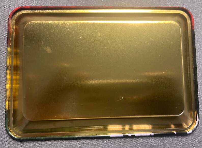 以下が含まれることがあります： 縁が高く、金色の金属製のトレイ。トレイはブラッシュ仕上げで、空です。