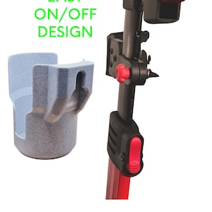 May include: A light blue, speckled plastic cup holder with the text "EASY ON/OFF DESIGN" in green. The holder is next to a black and red pole with a red button and knob.