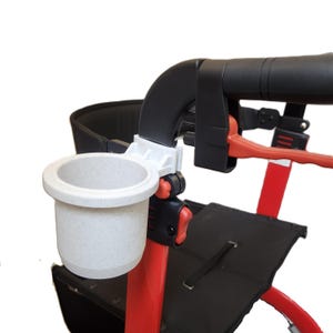 May include: A white speckled cup holder attached to a red and black walker. The cup holder is made of a light-colored, speckled material. The walker has a black seat and handles, with red accents.