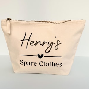 Peut inclure: Une trousse zipp&eacute;e en toile beige avec le nom "Henry's" en &eacute;criture noire, un c&oelig;ur et les mots "Spare Clothes". La trousse a une tirette de fermeture &eacute;clair &agrave; pompon.