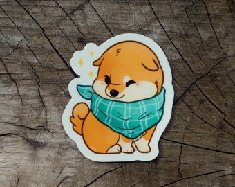May include: A sticker of a cartoon Shiba Inu dog wearing a teal and white plaid scarf. The dog is winking and has a happy expression.