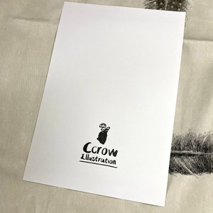K&ouml;nnte beinhalten: Eine wei&szlig;e Karte mit einer schwarzen Kr&auml;he Illustration und dem Text "Crow Illustration" darauf gedruckt.