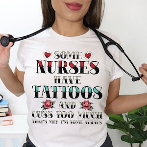 May include: White t-shirt with a red heart, the text "Some Nurses Have Tattoos And Cuss Too Much That's Me I'm Some Nurses" in black and red, and a red rose with green leaves.
