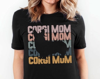 May include: Black t-shirt with a silhouette of a corgi dog and the text "Corgi Mom" repeated in a rainbow color scheme.