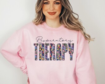 May include: A pink sweatshirt with the text "Respiratory Therapy" in floral letters.