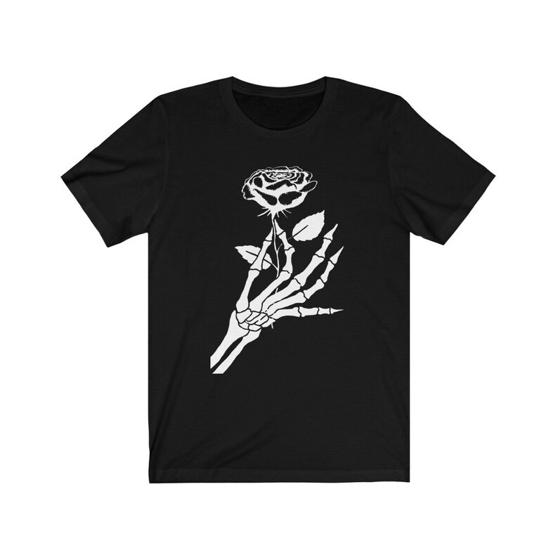 Puede incluir: Una camiseta negra con un gr&aacute;fico blanco de una mano esquel&eacute;tica sosteniendo una rosa.
