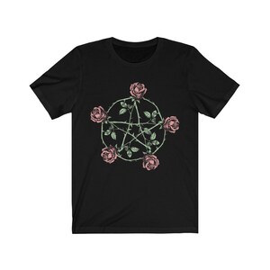 May include: Black t-shirt with a pentagram design made of thorns and roses. The roses are pink and the thorns are green.