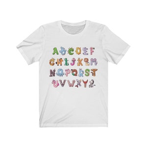 May include: White t-shirt with a colorful alphabet printed on it. Each letter is formed by a different animal.