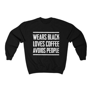 May include: Black sweatshirt with white text that reads "Wears Black Loves Coffee Avoids People".