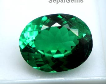 Könnte beinhalten: Ein lebendiger, oval geschliffener Smaragd-Edelstein, präsentiert in einer weißen Kunststoffbox. Der Edelstein hat eine tiefe, satte grüne Farbe mit vielen Facetten, die das Licht reflektieren. Der Text "SepalGems" ist sichtbar.