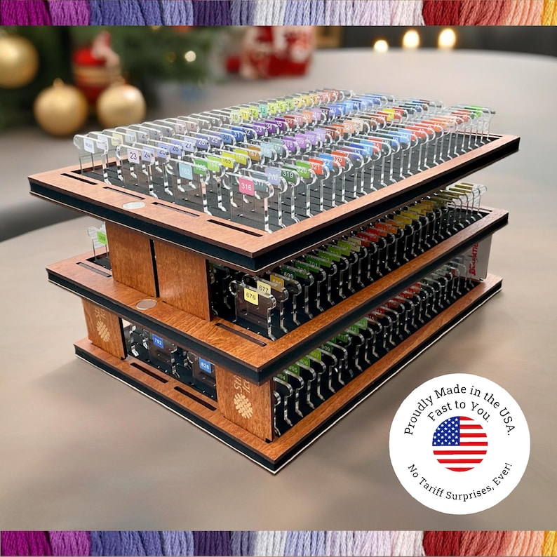 May include: A three-tiered wooden organizer with multiple compartments, filled with colorful thread spools. Each spool is labeled with a number. The organizer has a black trim and a circular sticker that says "Proudly Made in the USA. Fast to You. No Tariff Surprises, Ever!"