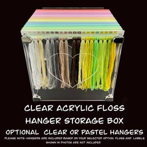 May include: Clear acrylic floss hanger storage box with a rainbow of pastel-colored dividers. The box holds various colors of floss, from white to shades of green and brown. The text on the image reads "CLEAR ACRYLIC FLOSS HANGER STORAGE BOX".