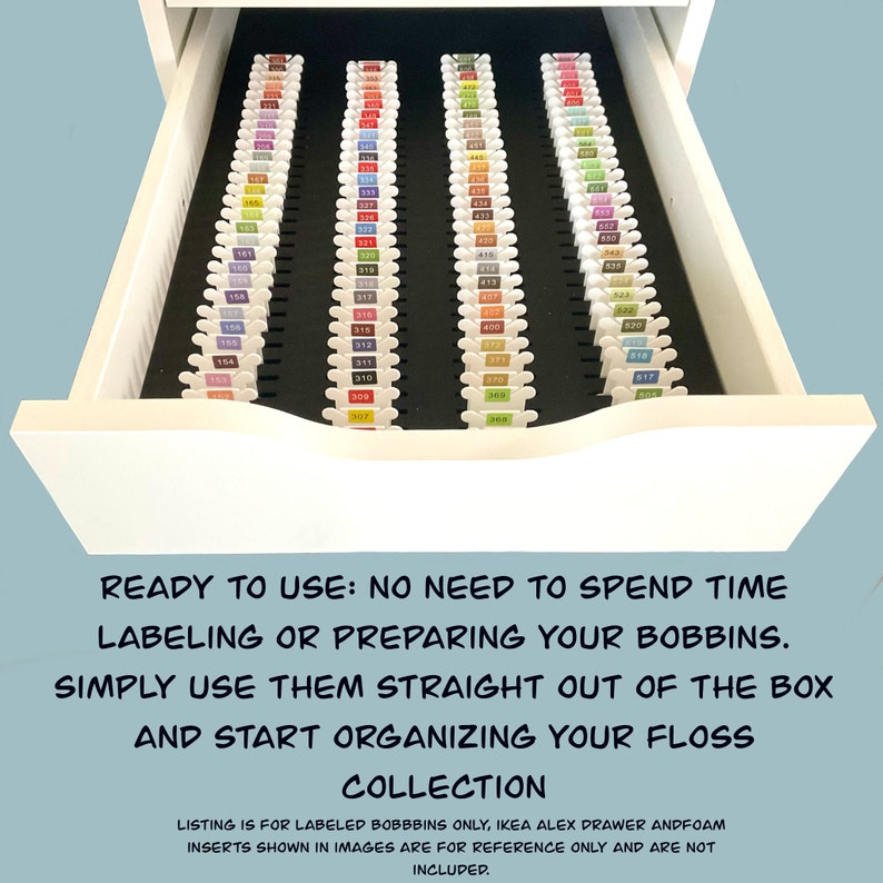 May include: A white drawer with a black foam insert for organizing embroidery floss. The drawer is full of labeled bobbins of floss in various colors. The text on the drawer reads "READY TO USE: NO NEED TO SPEND TIME LABELING OR PREPARING YOUR BOBBINS. SIMPLY USE THEM STRAIGHT OUT OF THE BOX AND START ORGANIZING YOUR FLOSS COLLECTION".