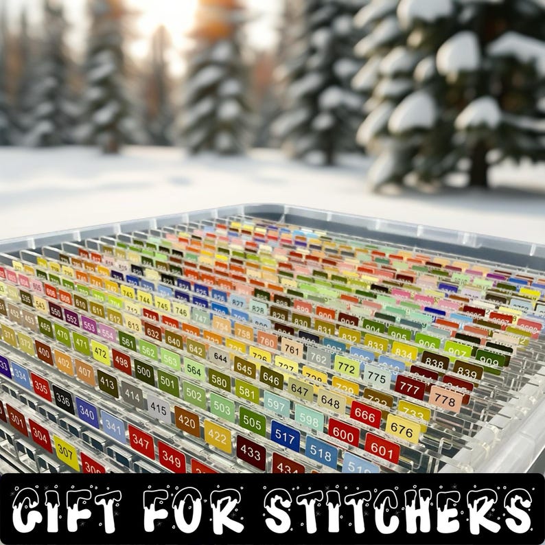 May include: A clear plastic organiser filled with colourful numbered labels, perfect for cross-stitch or embroidery projects. The labels are arranged in rows, with a variety of colours and numbers. The text "GIFT FOR STITCHERS" is at the bottom.