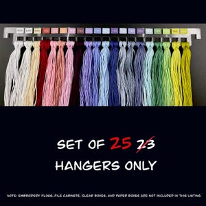 May include: A set of 23 embroidery floss thread hangers in various colours, including white, red, pink, purple, blue, green, and yellow. The hangers are attached to a metal bar with colour codes. The text "SET OF 25 HANGERS ONLY" is displayed.