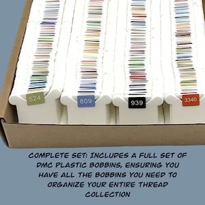 May include: A full set of DMC plastic bobbins for organizing embroidery floss. The bobbins are arranged in a box and labeled with numbers: 524, 809, 939, and 3340.