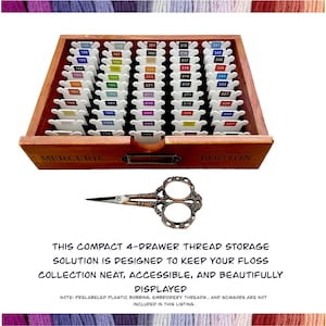 May include: A wooden thread storage box with four drawers labeled "Mercerie" and "Bouton". The box is filled with small plastic bobbins, each labeled with a number. A pair of antique-style scissors is in front of the box. The text below the box reads "This compact 4-drawer thread storage solution is designed to keep your floss collection neat, accessible, and beautifully displayed. Note: Prelabeled plastic bobbins, embroidery threads, and scissors are not included in this listing."