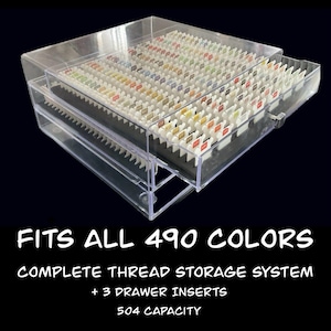 May include: Clear plastic thread storage system with three drawers, filled with spools of colorful thread. The text "FITS ALL 490 COLORS" is displayed at the bottom, along with "COMPLETE THREAD STORAGE SYSTEM + 3 DRAWER INSERTS 504 CAPACITY".