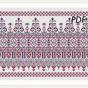 May include: A cross stitch pattern featuring a traditional folk design with red, blue, and white colors. The pattern includes geometric shapes and floral motifs. The text "PDF" is visible in the upper right corner of the image.
