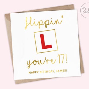 May include: White birthday card with gold foil lettering that reads "flippin' you're 17!" and "Happy Birthday, James!" A red "L" in a gold square is in the center. The card is in a brown envelope.